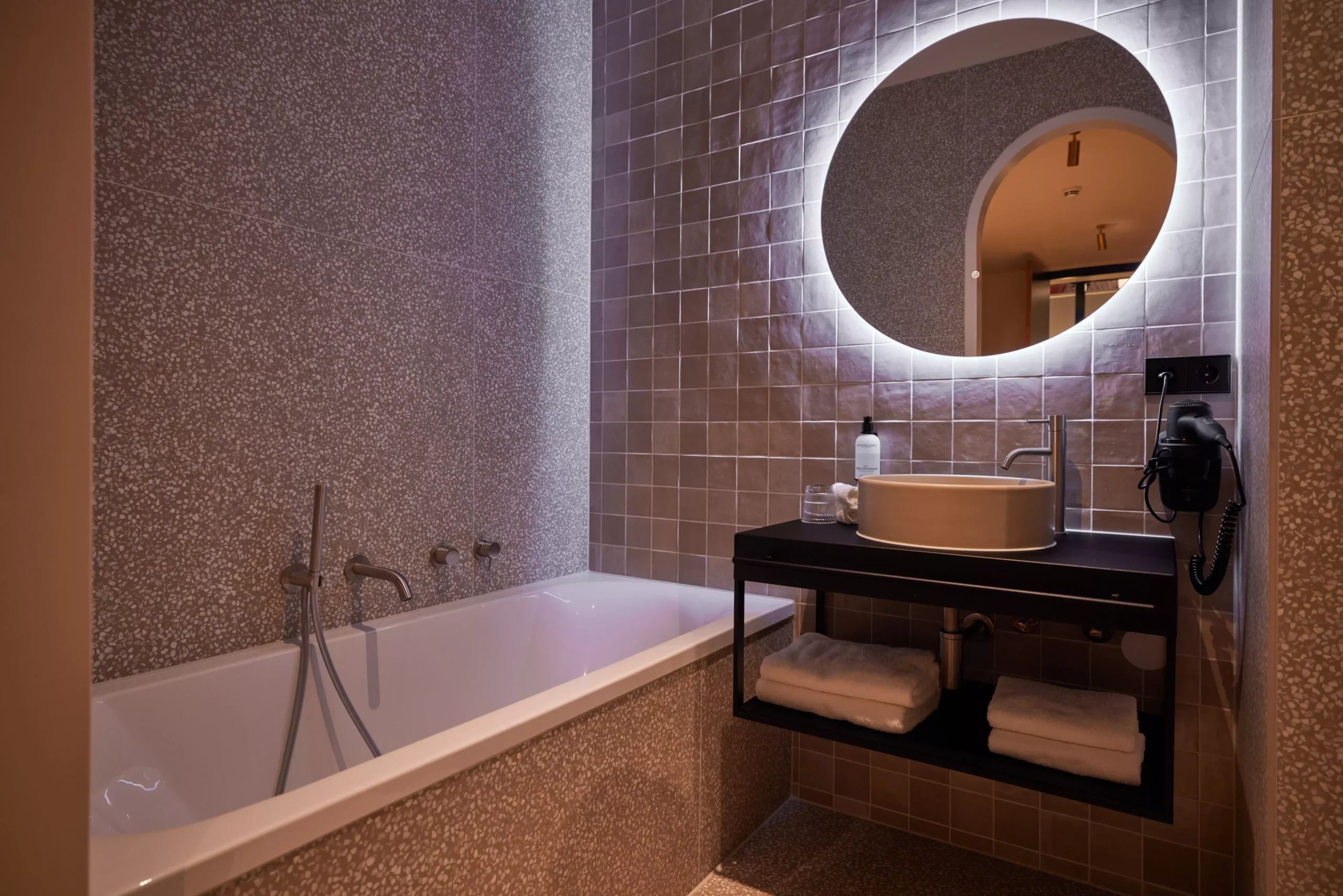 Badkamer van de Deluxe kamer met ruime inloopdouche en ronde spiegel bij Heavens Hotel Hoorn