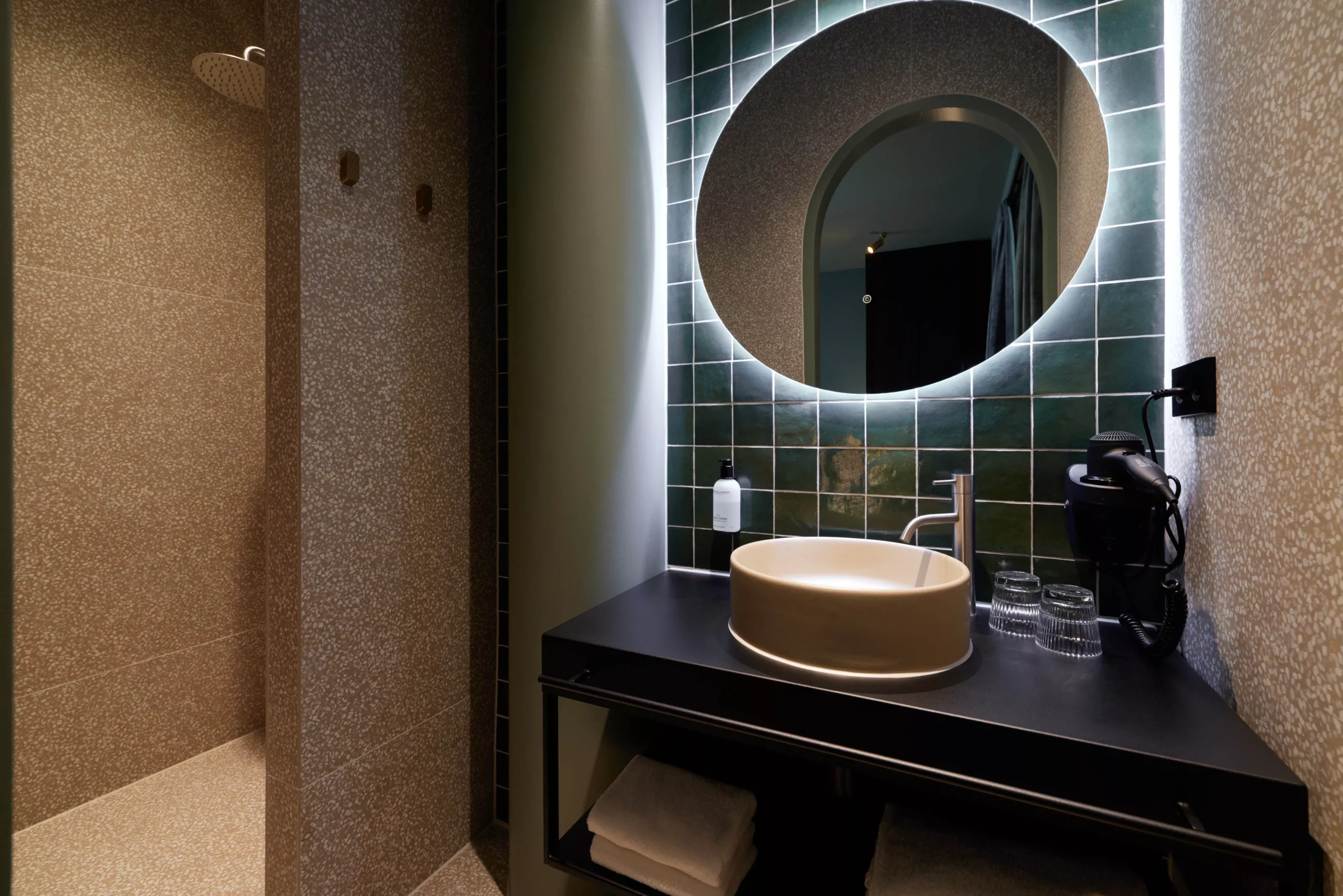 Design badkamer van de Deluxe kamer met groene tegels en moderne afwerking