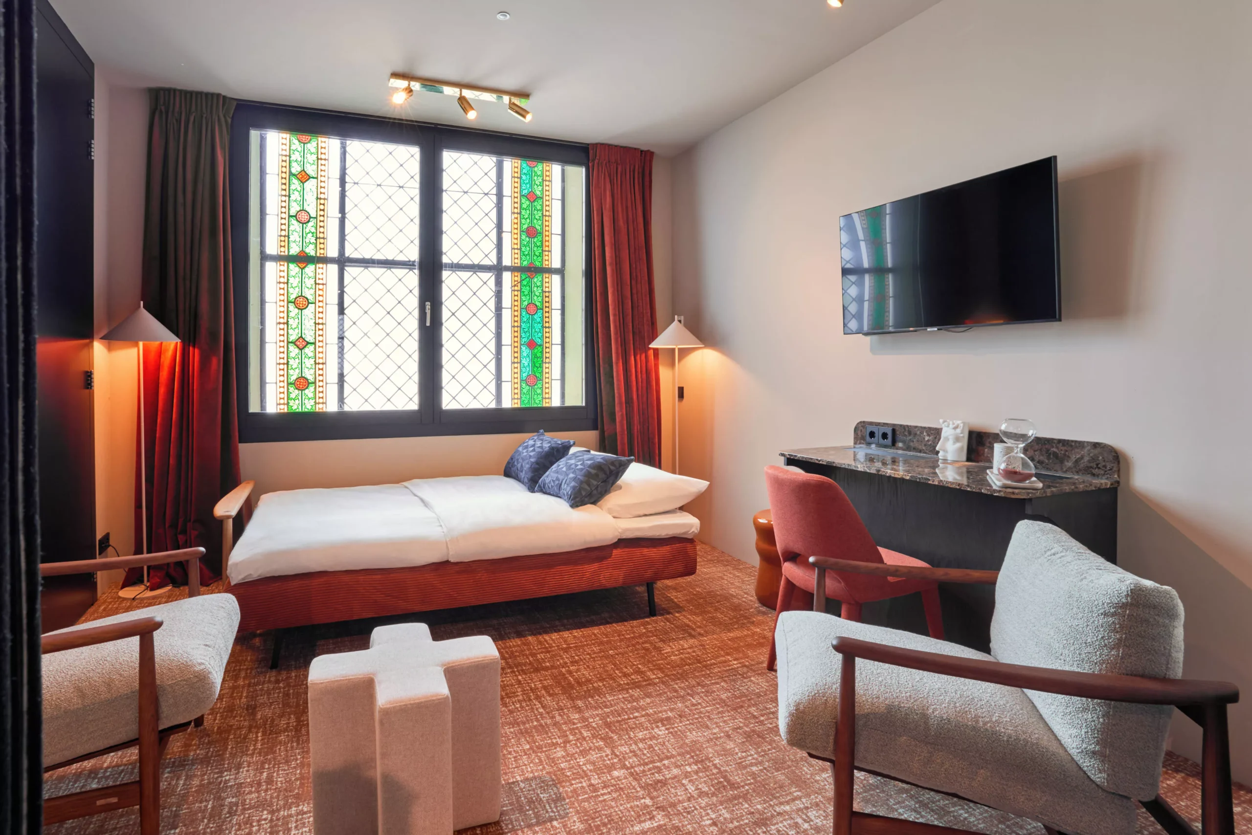 Tweede slaapgedeelte in de Family Suite met bank, tv en warme verlichting in Heavens Hotel Hoorn